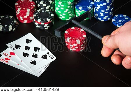 Poker Cards With Three Of A Kind Or Set Combination. Rake For Chips In Hand