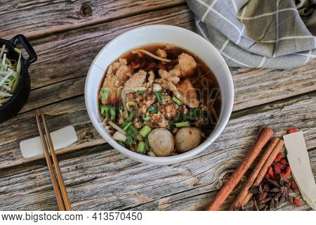 Egg Noodle With Pork And Vegetable In Five Spices Black Soup On Wooden Table Top View
