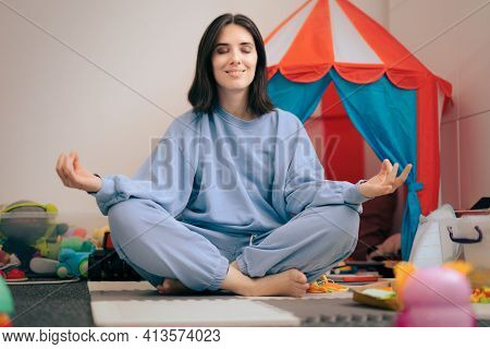 Carefree Mother Sitting In Lotus Position Surrounded By Toys
