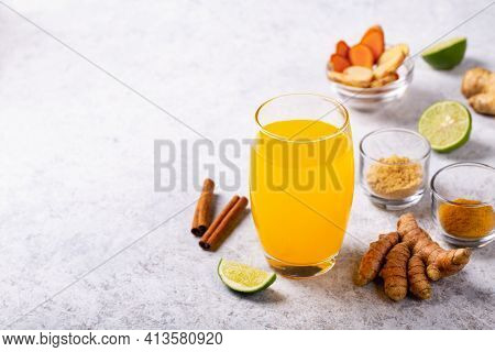 Healthy Drink From Turmeric And Ginger Roots And Lime In A Glass On White Concrete Background With C