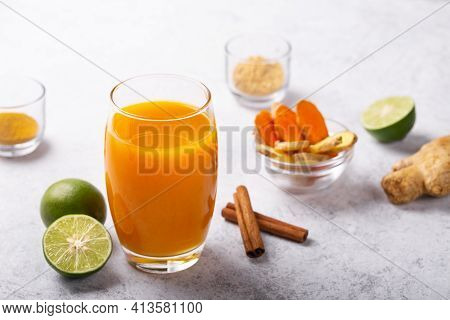 Healthy Drink From Turmeric And Ginger Roots And Lime In A Glass On White Concrete Background With C