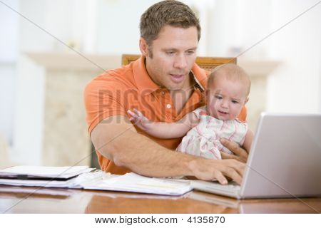 Far og Baby i spisestuen med Laptop