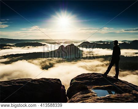 Man Standing On A Rock Sorrounded By Clouds On Trek Summit. Winterberg Rock In The Saxon Switzerland