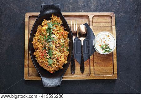 Biryani, On A Black Stony Background, Top View. Traditional Indian Cuisine. An Orintal, Baked Dish M