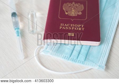 Syringe With Needle, Vial, Surgical Face Mask And Russian Passport On A White Table Ready To Be Used