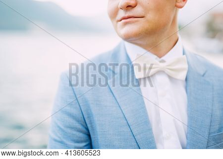 A Man In A Blue Jacket And A White Bow Tie Stands By The Sea, Close-up