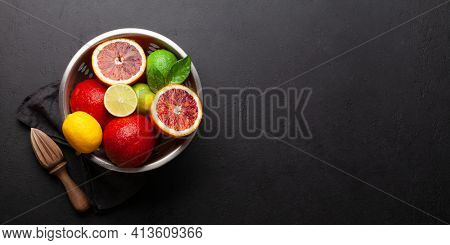 Various fresh citrus fruits in colander. Bood orange, lime, lemon. Top view flat lay with copy space