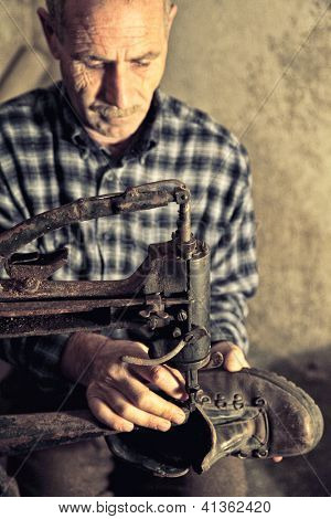 cobbler at work with old tools