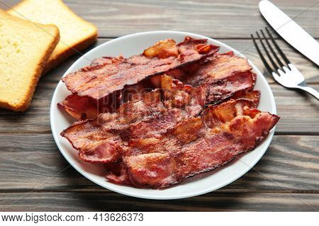 Bacon Fried Slices In Plate On Brown Background.