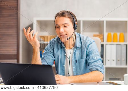 Workplace of freelance worker or sudent at home office. Young man works using computer and other devices. Remote job.
