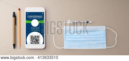 Flat Lay Top View Desk Working Space With Smartpone, Covid Pass, Vaccination And Coronavirus Concept