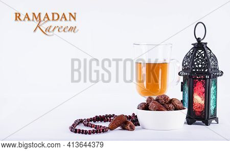 Ramadan Food And Drinks Concept. Ramadan Arabian Lamp, Wood Rosary, Tea, And Dates Fruit On White Ba