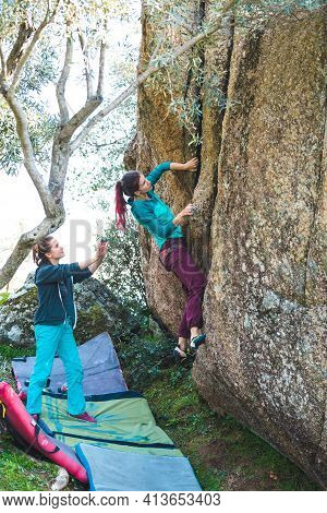 Friends Go In For Sports In Nature, Bouldering On Rocks, Girl Climbs A Big Stone, Woman Is Belayng P