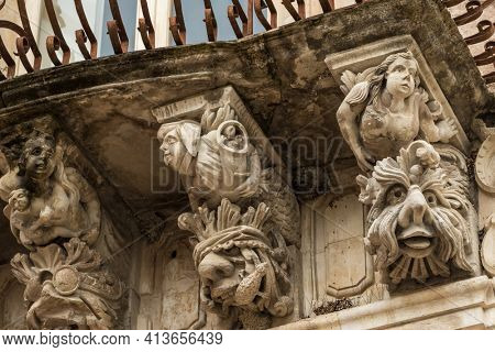Beautiful baroque mascaron ornament of a balcony in the old town of Ragusa, Sicily, Italy