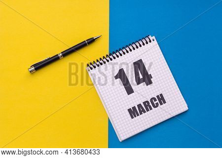 March 14th. Day 14 Of Month, Calendar Date. A Notebook With A Spiral And A Pen Lies On A Yellow-blue