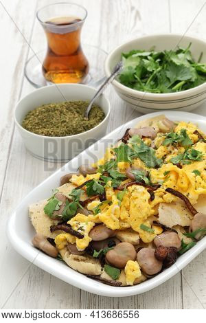 iraqi breakfast; boiled dried broad beans and scrambled eggs over pieces of flatbread