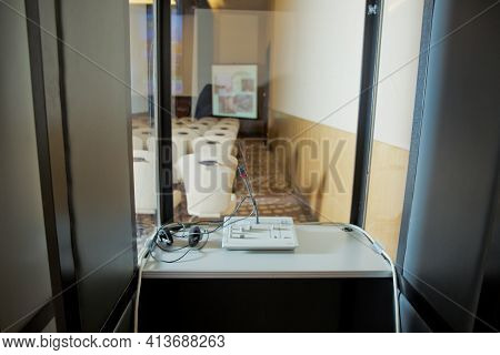 Soft Focus Of Wireless Conference Microphones And Notebook In A Meeting Room. Translators Cubicle . 