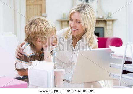 Žena a chlapec v domácí kanceláři s úsměvem a Laptop