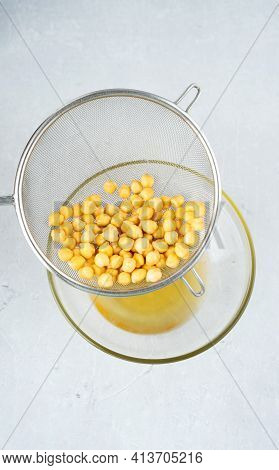 Chickpea Water Aquafaba. Egg Replacement. Vegan Concept. Metal Sieve Draining Aquafaba Chickpea Wate