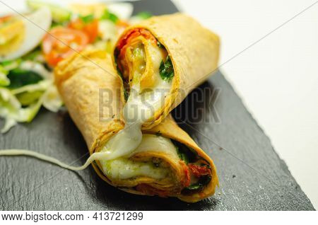 Tomato Tortilla Wrap With Mozzarella Cheese,  Tomatoes, Rocket, Basil Pesto,  And Mix Salad