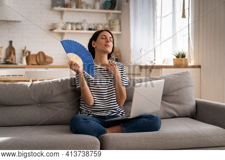 Tired Millennial Woman Suffers From Stuffiness And An Inoperative Air Conditioner, Waving Blue Fan S