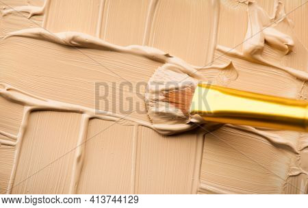 Foundation, concealer, face make-up smudge, smear. Cosmetic liquid foundation or cream beige color smudge, smear, stroke. Contouring, Makeup smears background. Brush. Foundation texture.
