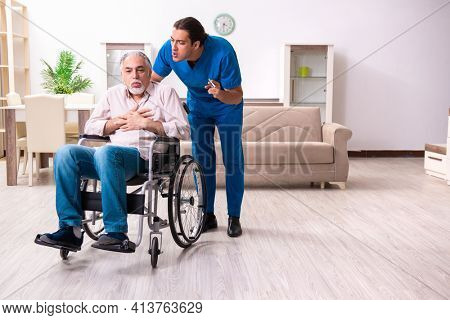 Old man in wheel-chair and young bad caregiver indoors