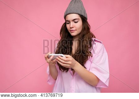 Photo Shot Of Attractive Positive Good Looking Young Woman Wearing Casual Stylish Outfit Poising Iso