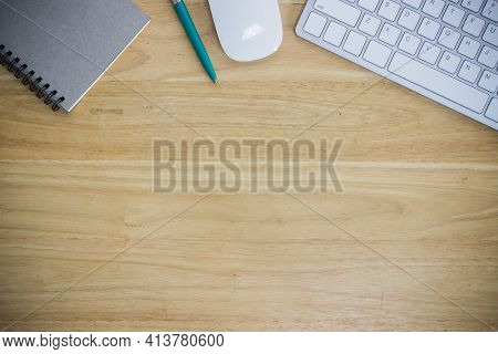 Workplace With Notebook And Keyboard, Mouse On Wooden Table