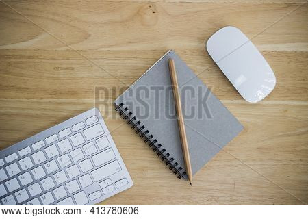 Workplace With Notebook And Keyboard, Mouse On Wooden Table