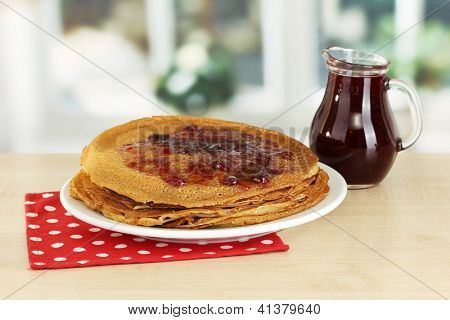 หวาน pancakes บนแผ่นกับแยมบนโต๊ะในห้องครัว