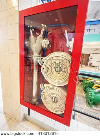 Box With Fire Hose And Nozzle, Fire Extinguisher In Factory. Fire Safety And Emergency Equipment In 