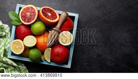 Various fresh citrus fruits in wooden box. Bood orange, lime, lemon. Top view flat lay with copy space