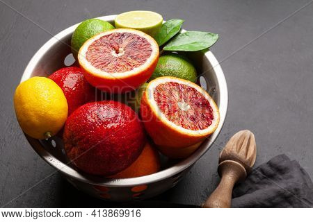 Various fresh citrus fruits in colander. Bood orange, lime, lemon. With copy space