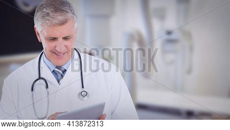 Portrait of caucasian senior male doctor using digital tablet at hospital. healthcare and professionalism concept