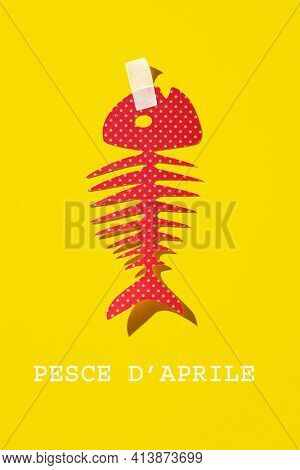 text fish of april written in italian, the equivalent of april fools day in italy, and a homemade paper fish, as a popular prank in this country, where it is typical to attach it to someones back