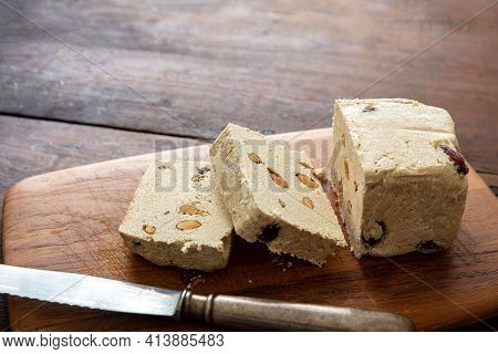 Halva Almond Nuts Slices On Wooden Table Background