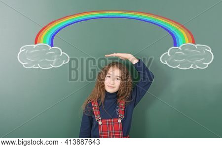Pre-adolescent Girl Stands Under Chalk Drawn Rainbow. Rainbow Emerges From The Cloud And Disappears 