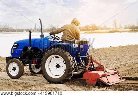 Farmer On A Tractor With Milling Machine Loosens, Grinds And Mixes Soil. Loosening The Surface, Cult