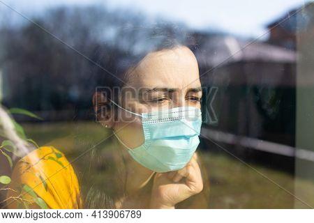 The Young Woman Is Looking Through The Window On Sunny Day