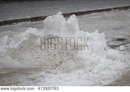 A Mountain Of Snow On The Street. Rainfall In The City In Spring. Removing Ice From Asphalt. Large P
