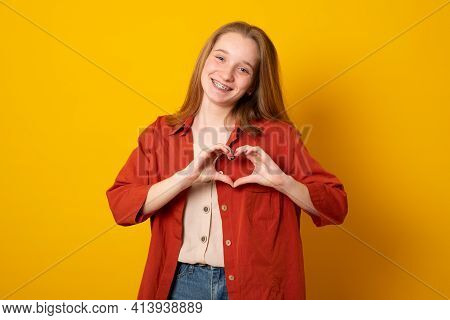 Be My Valnetine. Charming Young Girl Confesses In Love, Shows Heart Gesture, Smiles Broadly, Has Rom