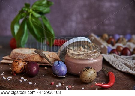 Meat Pate In A Glass Jar On A Cutting Board And Painted Quail Eggs. Easter Background, Meat Delicaci