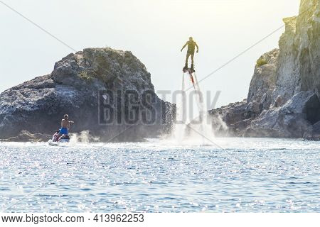 Man Rides On Flaybord The Sea. Sunny Autumn Day. Side View. Side View. Crimea, Sudak - 10 October 20
