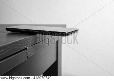 Smartphone Is Lying On The Edge Of The Table, Carelessly Left With The Possibility Of Falling.