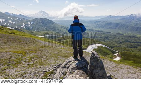 Kamchatka, Russia - July 10, 2018: Hiker Looking At The Ilyinsky Volcano, Kronotsky Reserve