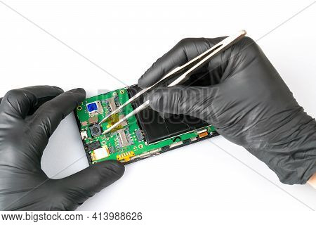 Fix The Phone.a Technician Or Master Repairs A Mobile Phone, He Installs And Changes The Camera In T