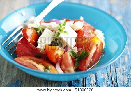 tomato,onion,feta salad sprinkled with fresh basil, capers and virgin olive oil