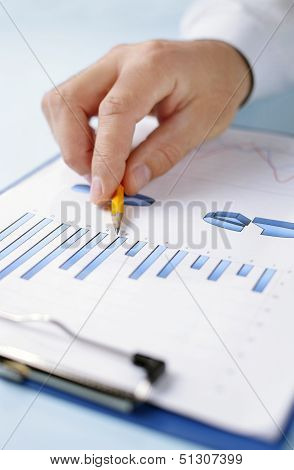 Man Holding A Pencil Working On A Graph