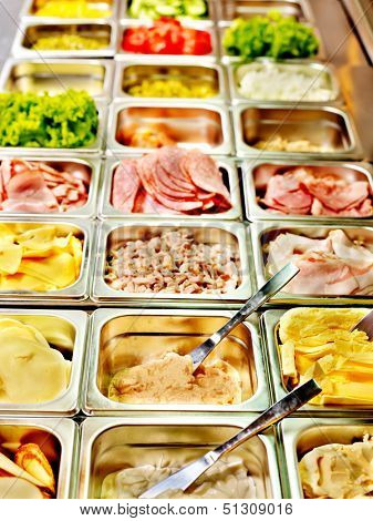 Tray with cooked food on showcase at cafeteria.